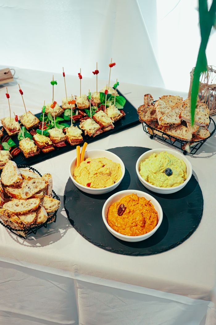 A vibrant selection of dips with assorted breads and bite-sized snacks on display for a party or gathering.