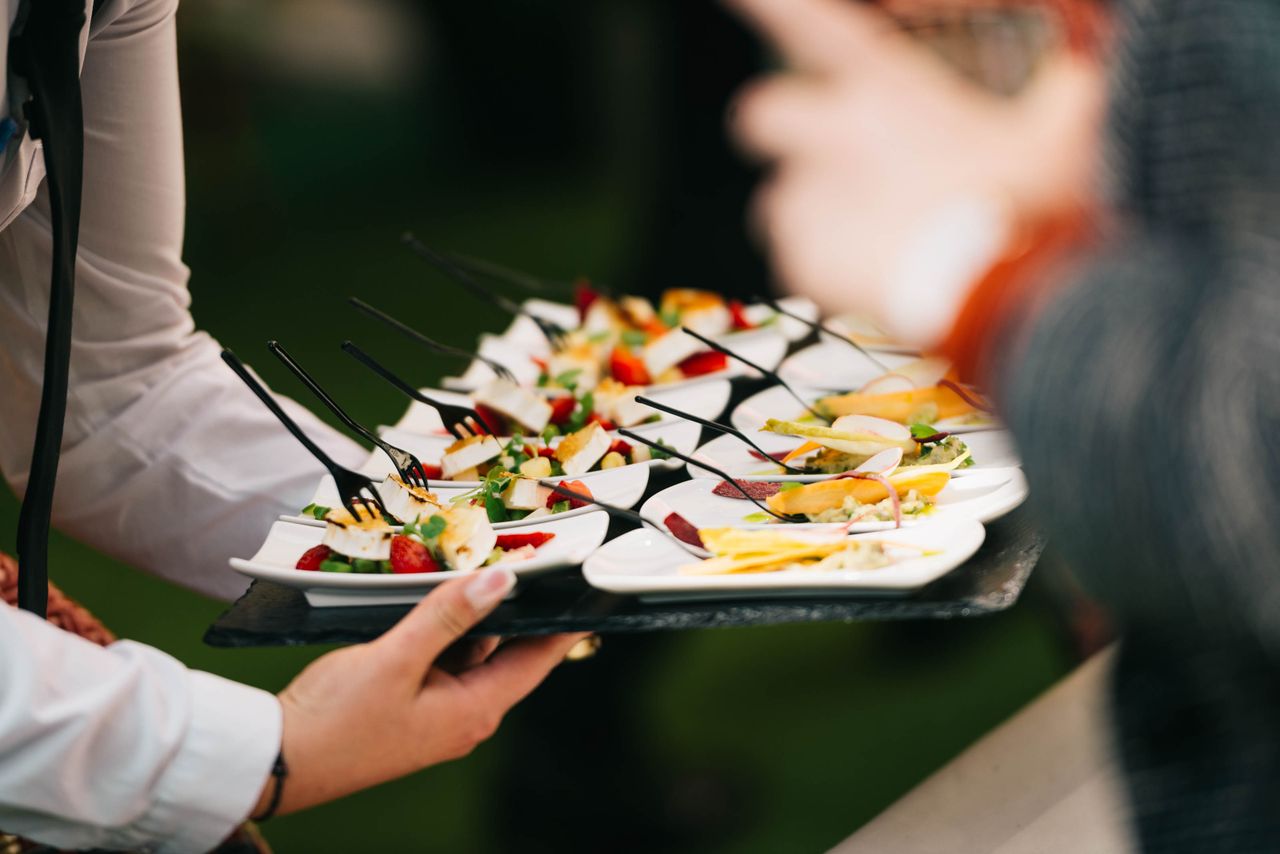 Présentation élégante de traiteur avec des amuse-bouches gastronomiques sur un plateau lors d'un événement.