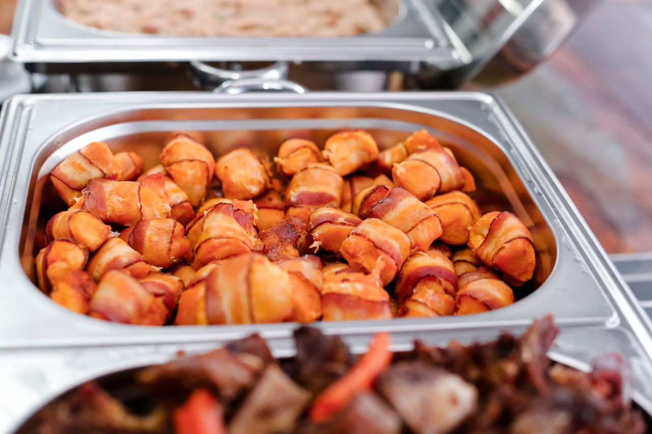 De délicieuses bouchées enrobées de bacon, prêtes à servir sur un plateau traiteur. Idéales pour les événements.